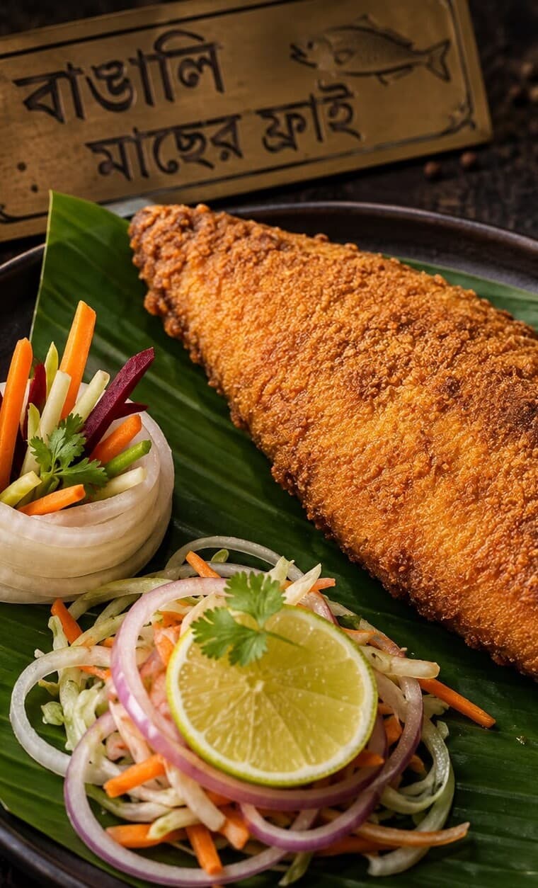 A fish fry plated on a banana leaf with kacha salad